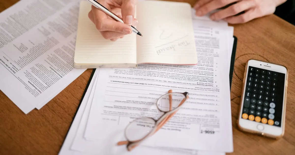 Tax documents and a notice of assessment on a desk while comparing CRA debt consumer proposal options