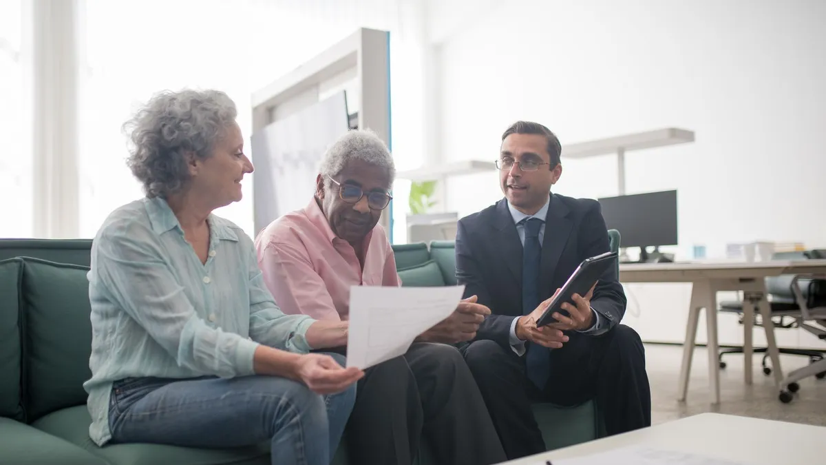 Licensed advisor explaining the difference between debt forgiveness and a consumer proposal to a client across a desk