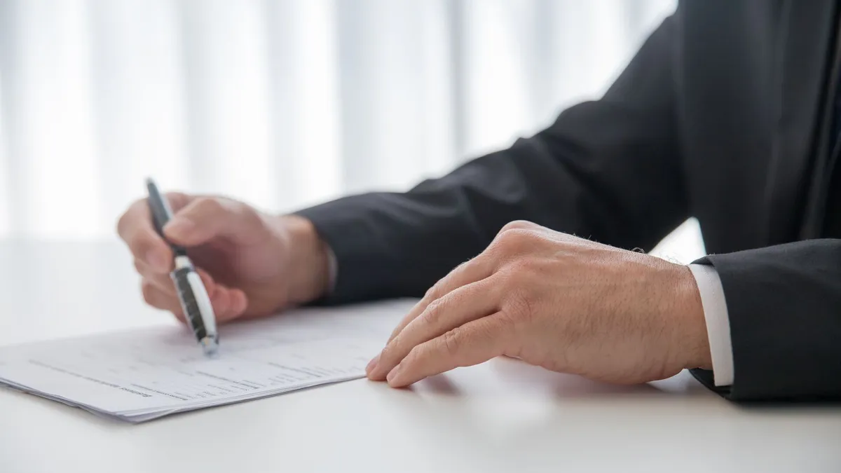 Advisor across a desk explaining Canadian debt relief options to a client holding a folder of statements