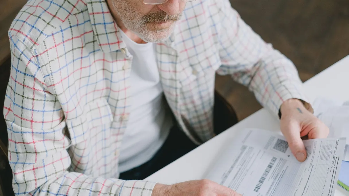 Retired man reviewing pension debt relief documents at home